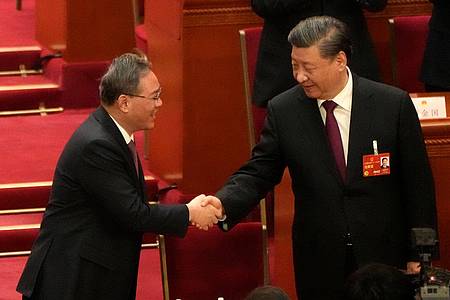 Xi Jinping (r), Chinas Staats- und Parteichef, wird von Li Qiang beglückwünscht, nachdem er erneut einstimmig zum Präsidenten gewählt wurde.