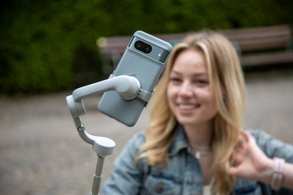 Frau macht Foto von sich selbst mit Selfiestick