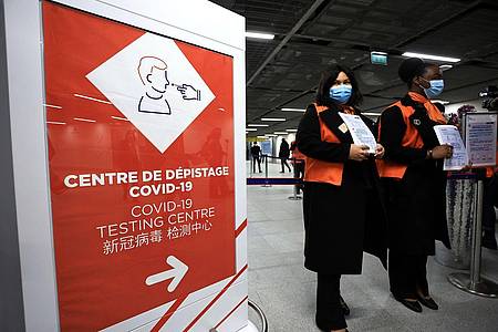 Zwei Flughafenmitarbeiterinnen warten auf dem französischen Flughafen Roissy-Charles de Gaulle auf Passagiere aus China.