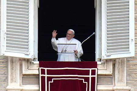 Papst Franziskus winkt während des Angelus-Mittagsgebets aus dem Fenster seines Arbeitszimmers mit Blick auf den Petersplatz.
