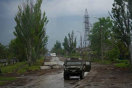 Ein russisches gepanzertes Fahrzeug bewacht die Straße zum belagerten Stahlwerk Azovstal während einer Evakuierung in Mariupol.