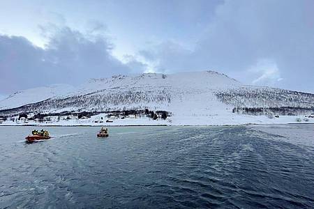 Rettungshelfer suchen nach einer Schneelawine auf der Insel Reinøya mit Booten nach Überlebenden.