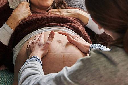 Eine Hebamme tastet den Bauch einer Schwangeren ab. Frauen sind im Durchschnitt bei der Geburt ihres ersten Kindes noch älter geworden.