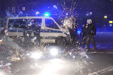 Polizeibeamte hinter explodierendem Feuerwerk in Berlin