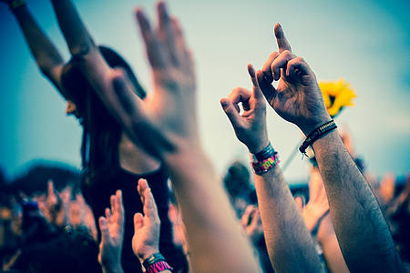 Menschen recken bei Festival die Hände in die Höhe