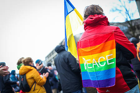 Person trägt eine Ukraineflagge und einen Peaceflagge