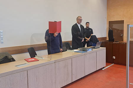 Angeklagter verbirgt sein Gesicht im Gerichtssaal