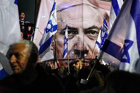 Demonstranten nehmen mit israelischen Fahnen an einem Protest gegen die Pläne der israelischen Regierung teil.