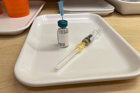 Impfstoff und Impfspritze auf Tisch