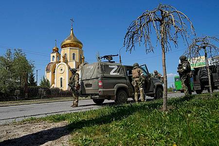 Russische Soldaten bewachen in Berdjansk im Gebiet der Donezker «Volksrepublik» in der Ostukraine den Bereich vor einer orthodoxen Kirche.