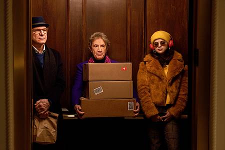 Die drei Protagonisten der Serie stehen in einem Aufzug
