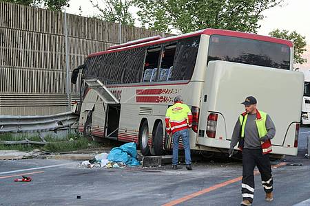 Der verunglückte Bus steht auf der Westautobahn bei Eugendorf an der beschädigten Leitplanke.