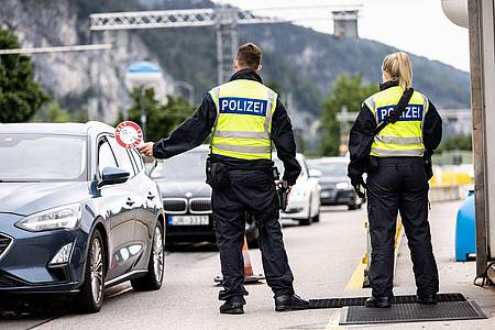 Deutsche Bundespolizisten beobachten an der Grenze zu Österreich auf der Autobahn A93 den Verkehr.