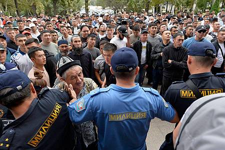 Polizisten drängen kirgisische Freiwillige zurück, die sich vor dem Regierungsgebäude versammeln und ihre Entsendung in die Konfliktzone an der kirgisisch-tadschikischen Grenze fordern.