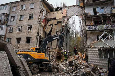 Ukrainische Rettungskräfte am zerstörten Gebäude, das durch russischen Beschuss massiv beschädigt wurde.