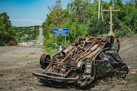 Ein zerstörtes Auto liegt auf einer Straße nach Dolyna. Das Dorf ist vier Kilometer von der Frontlinie zwischen den russischen und ukrainischen Streitkräften entfernt.