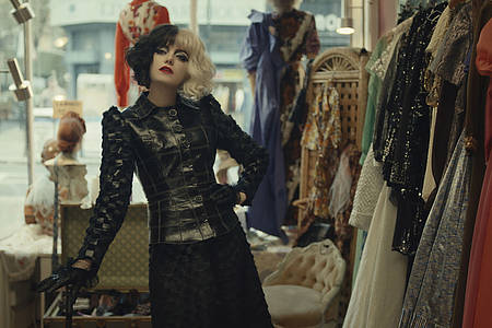 Cruella-Darstellerin Emma Stone vor einer Kleiderstange