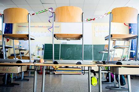 Stühle stehen nach Schulschluss auf den Tischen in einem Unterrichtsraum einer Grundschule.