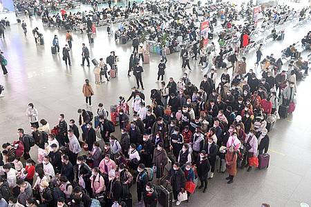 Zahlreiche Fahrgäste stehen in einem Bahnhof in der südchinesischen Provinz Guangdong Schlange.