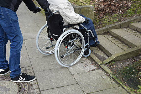 Pfleger mit Rollstuhl