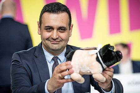 Der neugewählte FDP-Generalsekretär Bijan Djir-Sarai präsentiert ein geschenktes Glücksschwein.