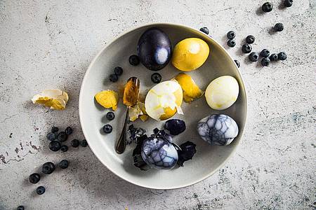 Für marmorierte Eier wird die Schale der bereits gekochten Eier angeknackst. So kommen sie dann in einen Sud etwa aus Essig Wasser, Salz, Zucker und einem natürlichen Farbstoff wie Blaubeeren, Kurkuma oder Rote Bete.