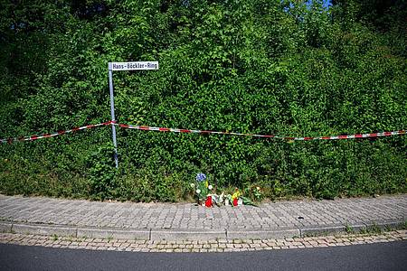 Menschen haben Kerzen, Blumen und Figuren am Tatort abgelegt, wo eine 15-Jährige getötet wurde.