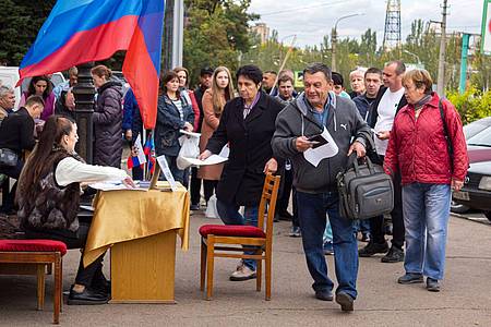 Menschen stellen sich in einer Reihe auf, um an einem Scheinreferendum in Luhansk teilzunehmen.