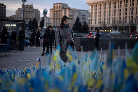Eine Frau betrachtet die ukrainischen Flaggen, die zum Gedenken an die Gefallenen des Krieges in der Nähe des Kiewer Maidan-Platzes aufgestellt wurden.