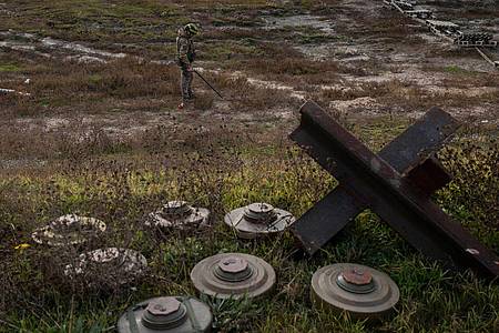 Ein ukrainischer Soldat sucht auf dem Feld eines kürzlich befreiten Dorfes am Rande von Cherson nach Minen.