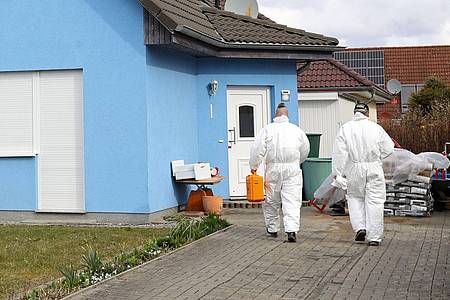 Mitarbeiter der Kriminaltechnik gehen in ein Haus in Rövershagen, in dem drei Menschen getötet worden sein sollen.