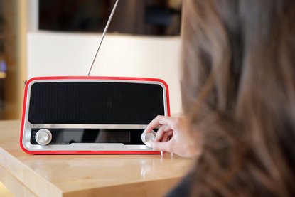 Frau dreht an einem Knopf am Radio