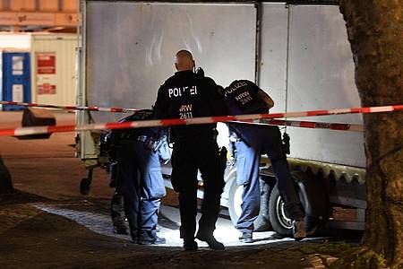 Polizisten suchen in der Nacht nach Spuren der Schiesserei auf dem Hamborner Altmarkt in Marxloh.