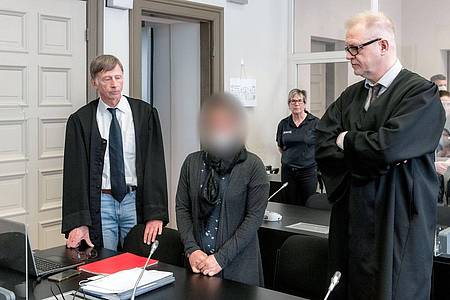 Die Angeklagte IS-Rückkehrerin aus Bremen steht zwischen ihren Verteidigern Jacob Hösl (r) und Johannes Pausch in einem Saal des Oberlandesgericht.