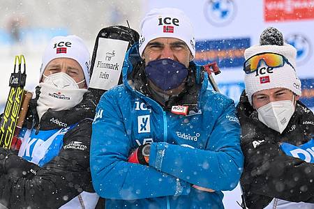 Norwegens Biathlon-Trainer Siegfried Mazet (M) steht zwischen seinen Athleten Tarjei Bö (l) und Sturla Holm Laegreid.