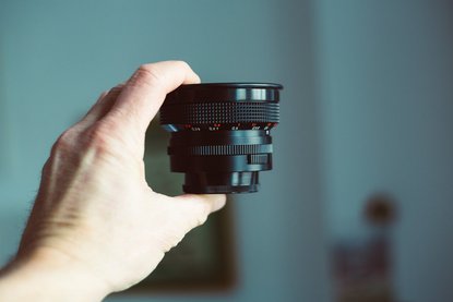 Hand hält Objektiv einer Kamera
