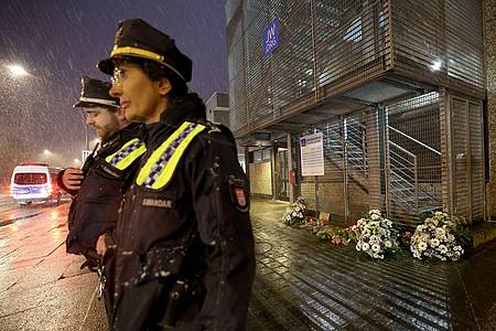 Polizeibeamte stehen im Hamburger Stadtteil Alsterdorf vor dem Gebäude der Zeugen Jehovas, wo ein Amokläufer erst sieben Mensch und dann sich selbst tötete.