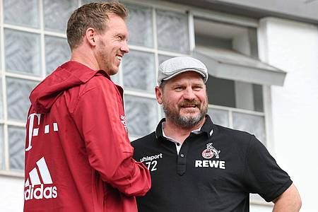 Bayerns Trainer Julian Nagelsmann (l) und Kölns Trainer Steffen Baumgart unterhalten sich.