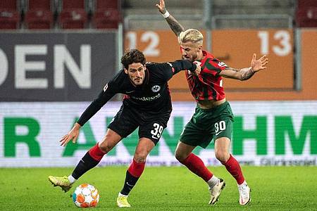 Goncalo Paciencia von Eintracht Frankfurt (l) schirmt den Ball gegen Augsburgs Niklas Dorsch ab. Foto: Matthias Balk/dpa