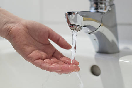 Hand unter Wasserhahn