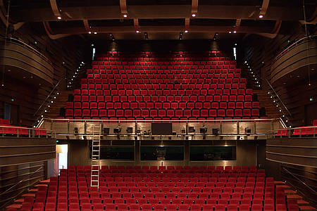 Blick von der Bühne auf die rot bestuhlten Ränge des Theaters in Bielefeld